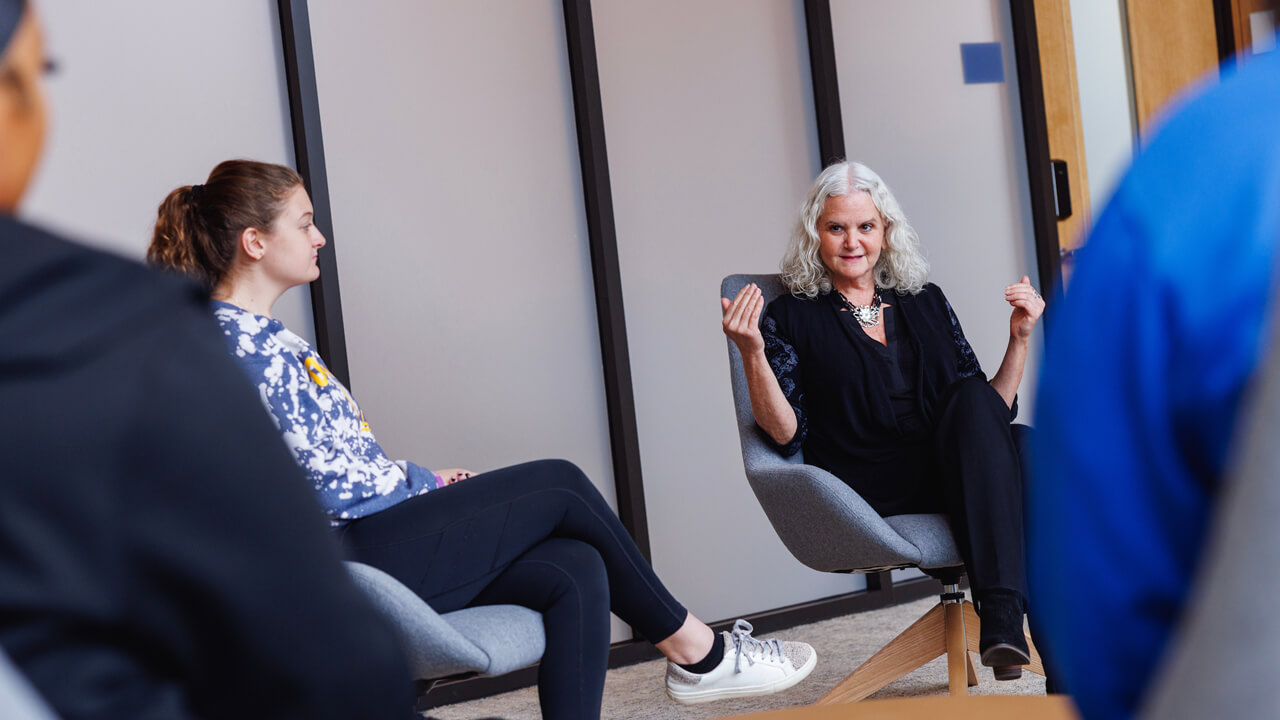 A professor of social work leads a discussion with students.