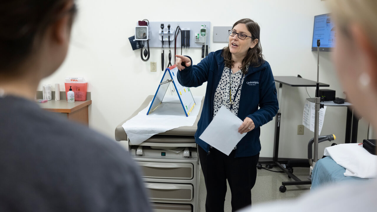 A professor of social work gives a lesson to students in a classroom.