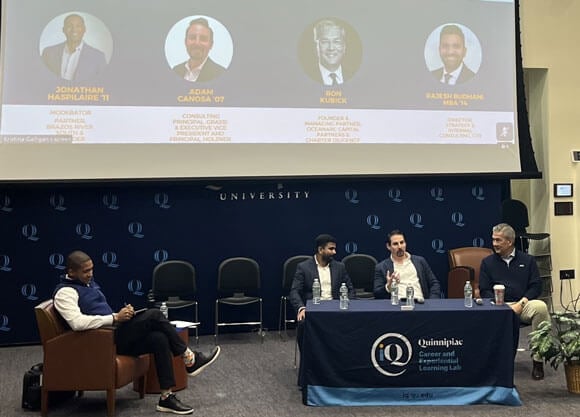 A panel speaks to an audience in the Mount Carmel Auditorium.