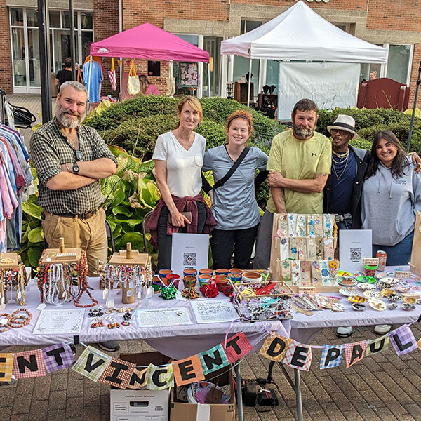 a group of people standing behind a table at an event.