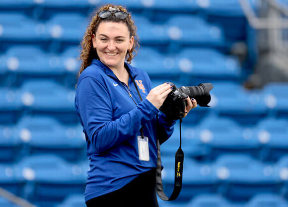 Photo of an individual with a camera in a stadium.